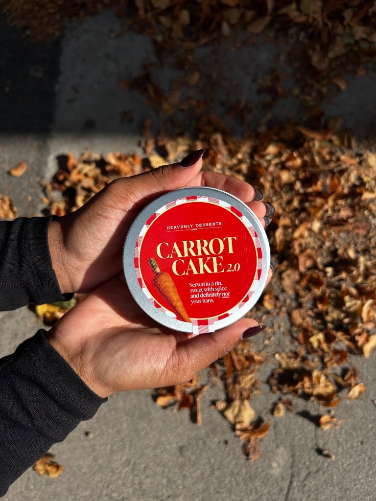 Guest presents a red-labelled carrot cake tin indoors