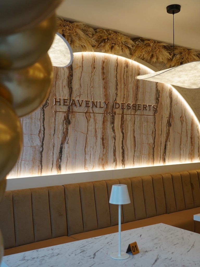 Salon feature wall with metallic lettering and warm stone textures